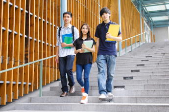 Students standing on stairs, holding books