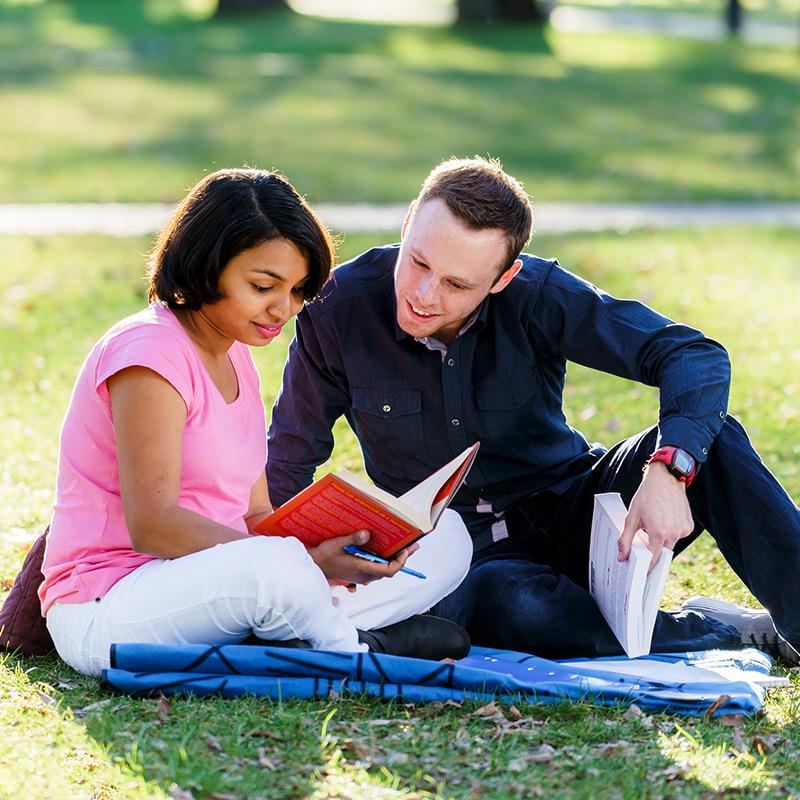Man and woman reading books in the park 