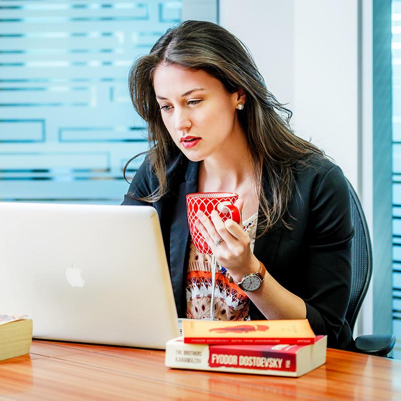 Professional woman on laptop drinking tea