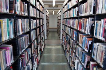aisle of books in a library fading into the distance