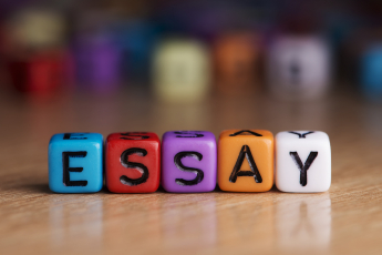 Essay words with dices on wooden table