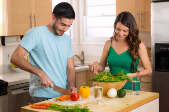 A couple preparing food together in a kitchen