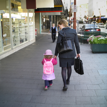 A professional working woman walking with a kid
